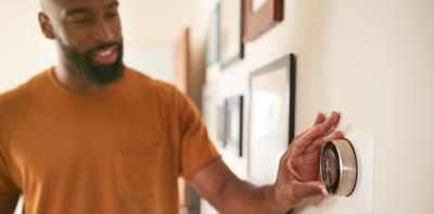 man adjusting thermostat