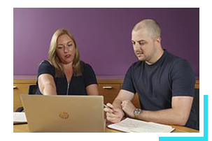 Two colleagues talking in a meeting with laptop