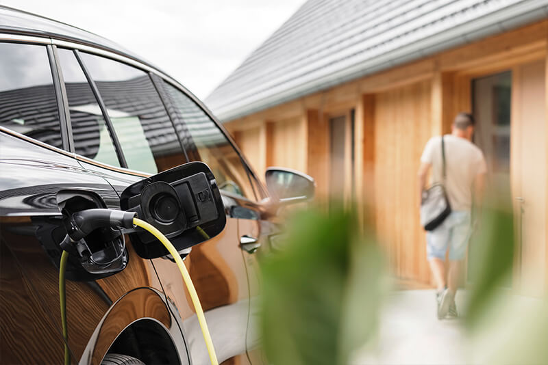 car with charge lead outside house