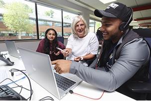 3 employees discussing and looking at computer