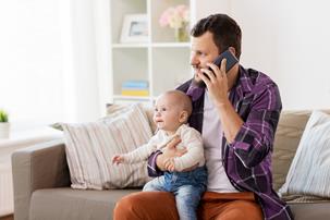 Man with baby speaking on the phone