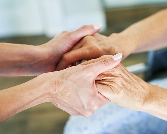 close up of two people holding hands for support