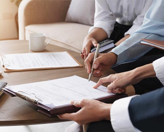 close up of two people sitting at desk with papers
