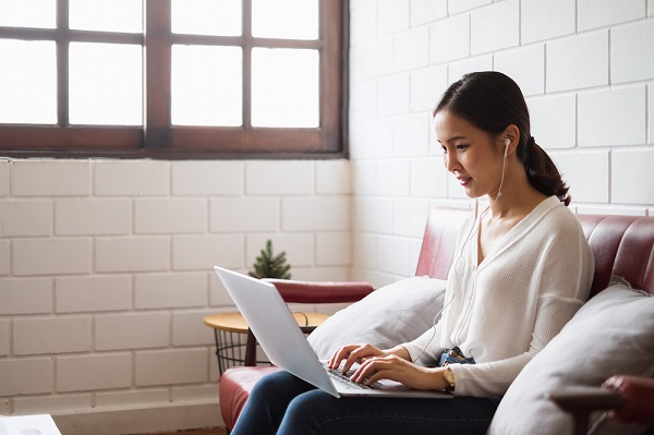 Asian woman sitting with laptop at home