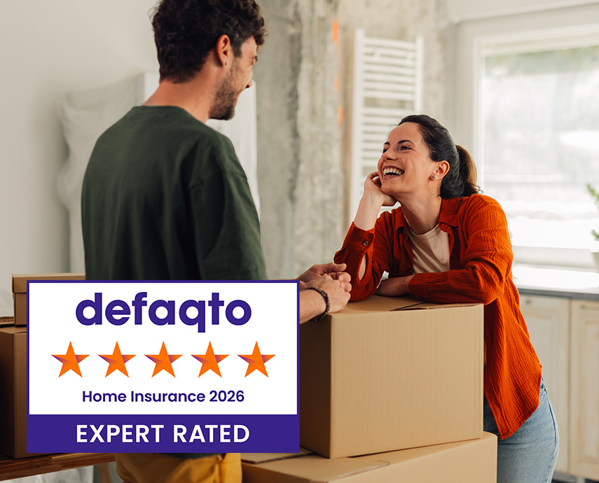 Young white smiling couple with boxes as they move into home