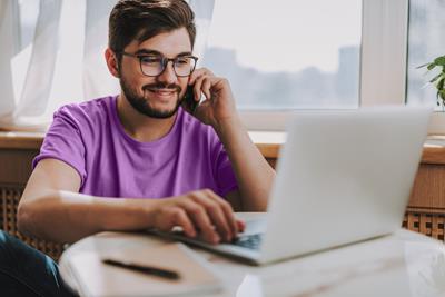 Young man on the phone with laptop