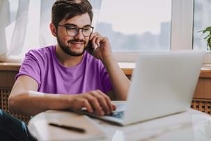 Young man on the phone with laptop