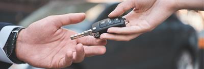 Close up of people handing car keys over 