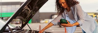 woman with oil in hand, and car bonnet up