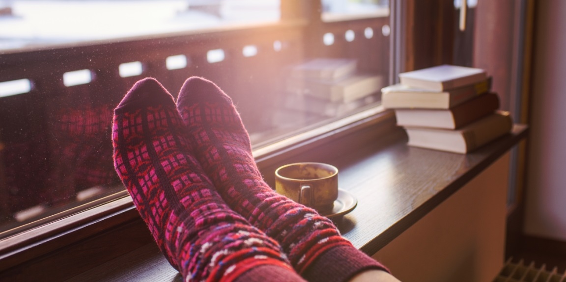 woman with socks on in warm home during winter