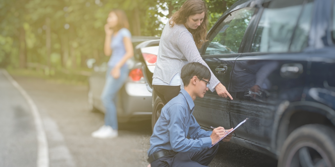 man inspecting car damage following a car accident