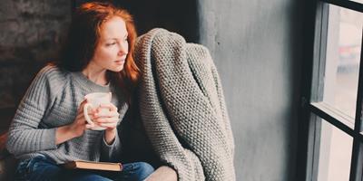 woman sitting in warm home during winter