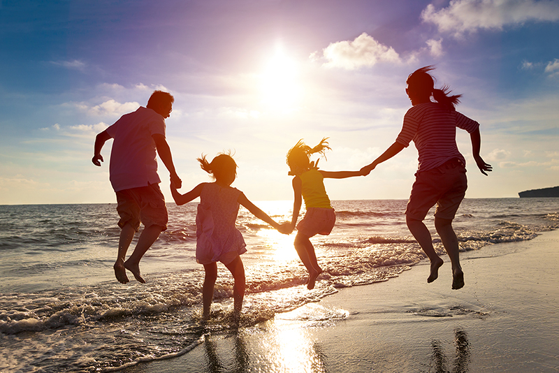 Family on beach with sunset