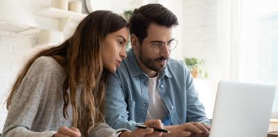 Couple using laptop at home