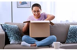 Girl on sofa opening package