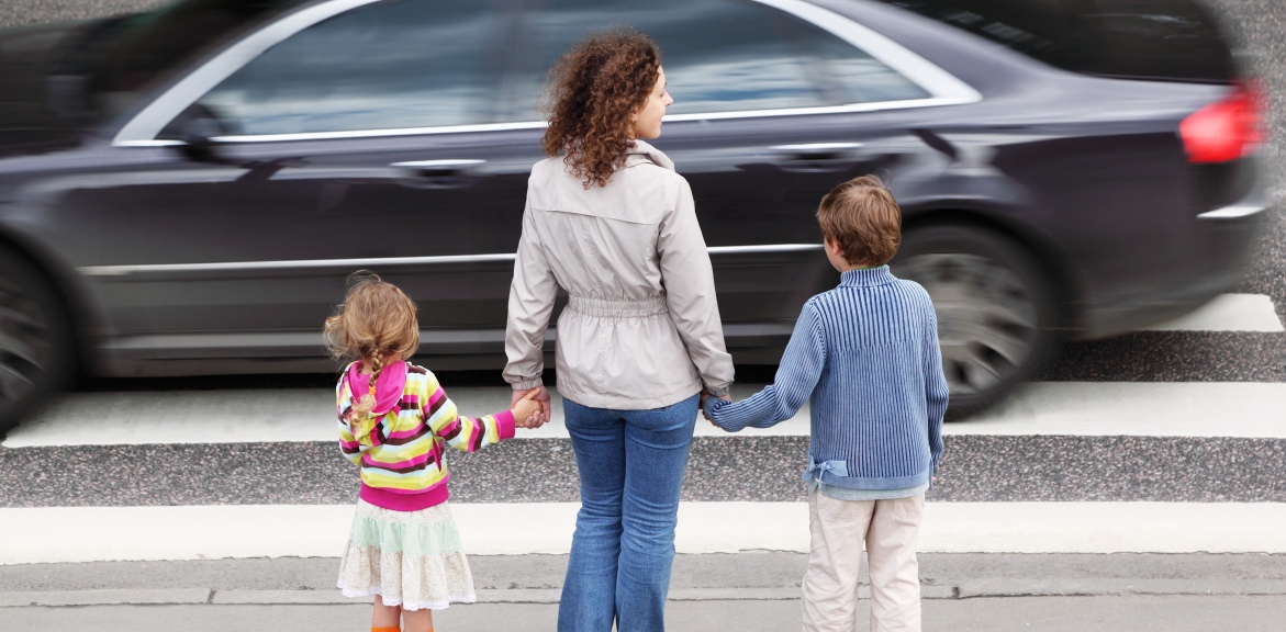 mother and two children waiting to cross a zebra crossing