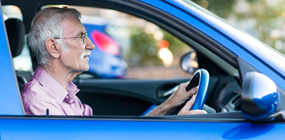 Elderly driver wearing glasses while driving
