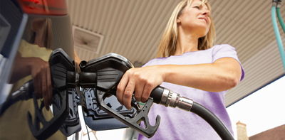 woman putting fuel into her car at petrol station