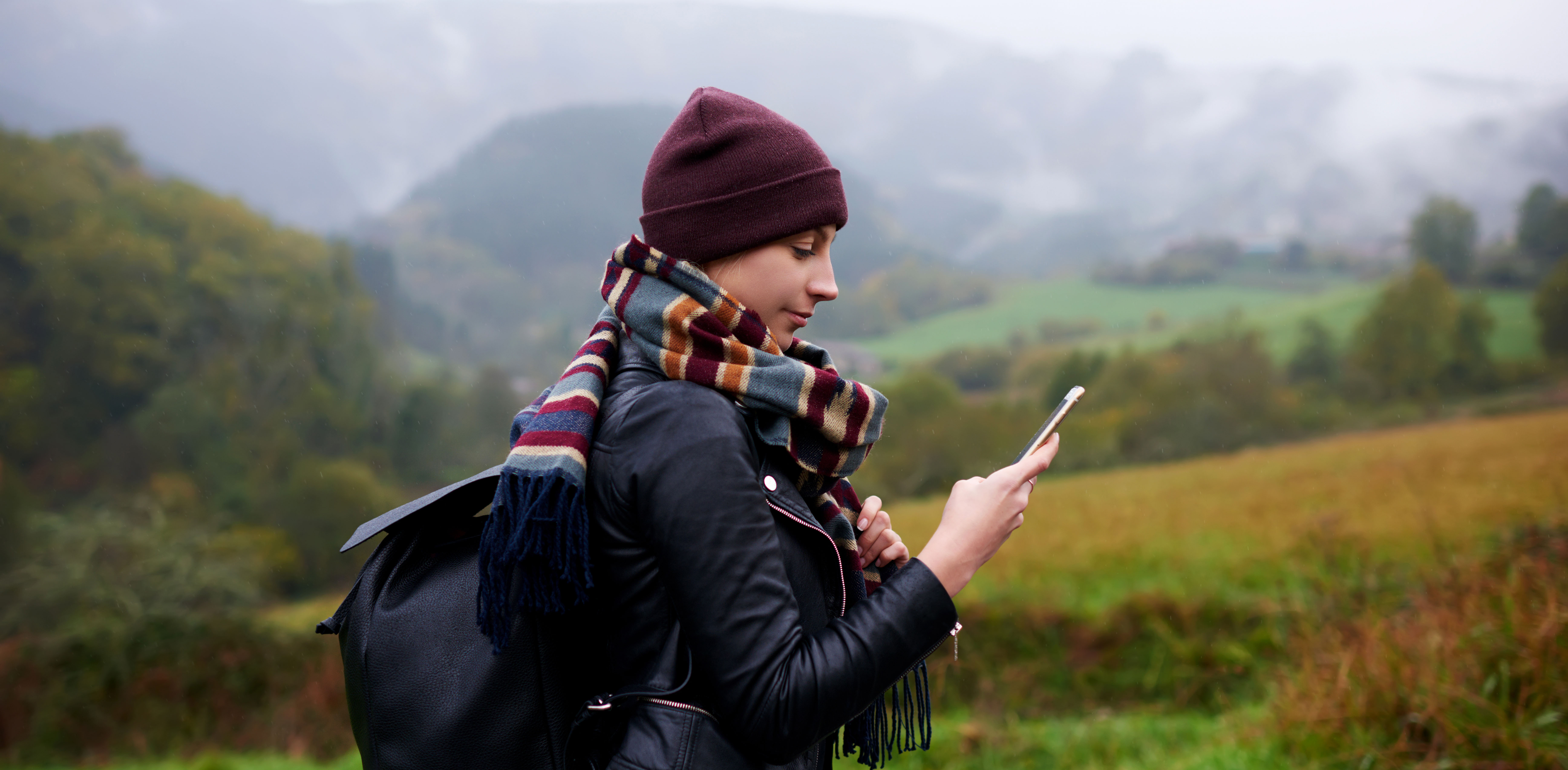 woman dressed for cold weather checking her phone
