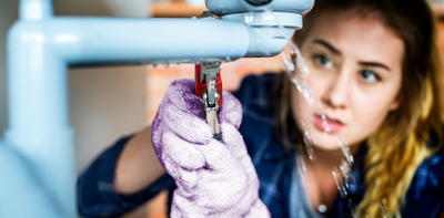 woman fixing leaking pipe at home