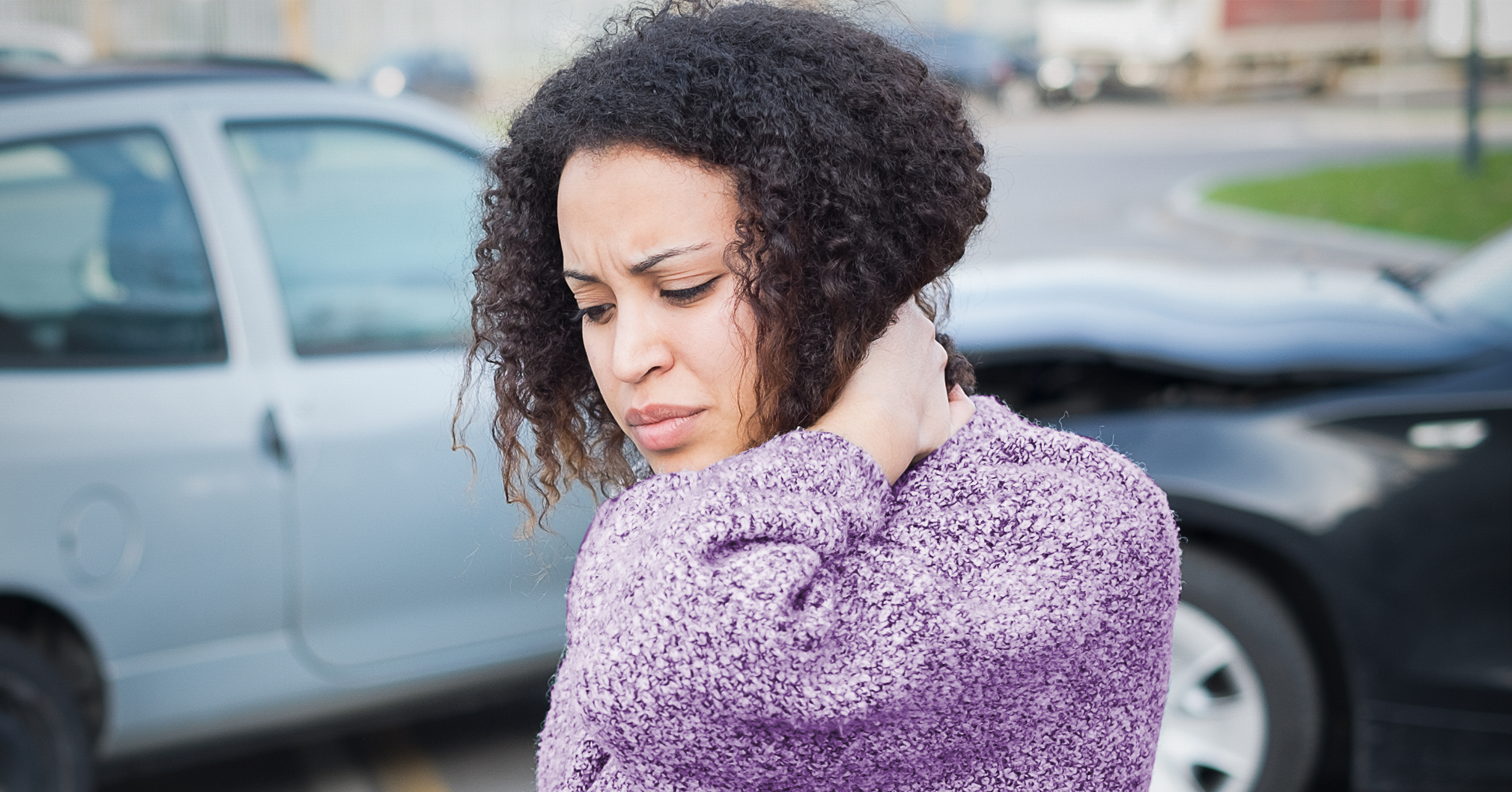 woman holding neck in pain following car accident