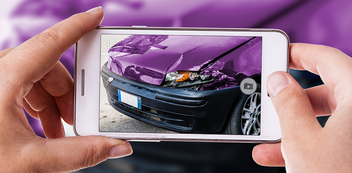 driver taking photo of damage to car following car accident