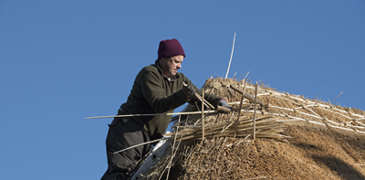 man thatching a roof