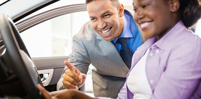 salesman showing off car features to a customer