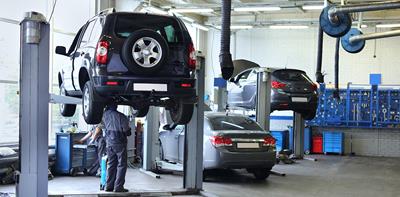 man inspecting cars in garage