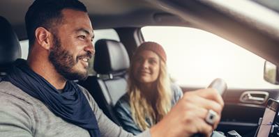 man and woman driving in car