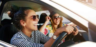 young women driving smiling sunglasses