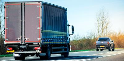 lorry following a car on the road