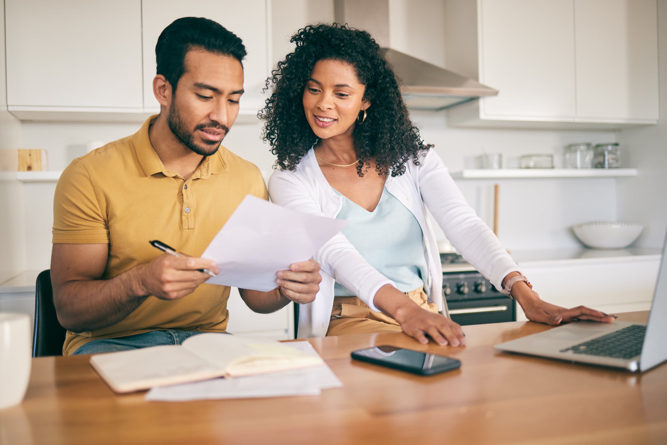 man and a woman looking at paper documents in a kitchen
