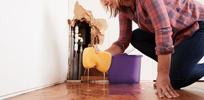 Woman cleaning up after water leak