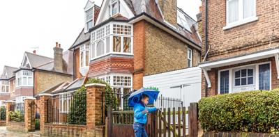 Kid with an umbrella going into his home